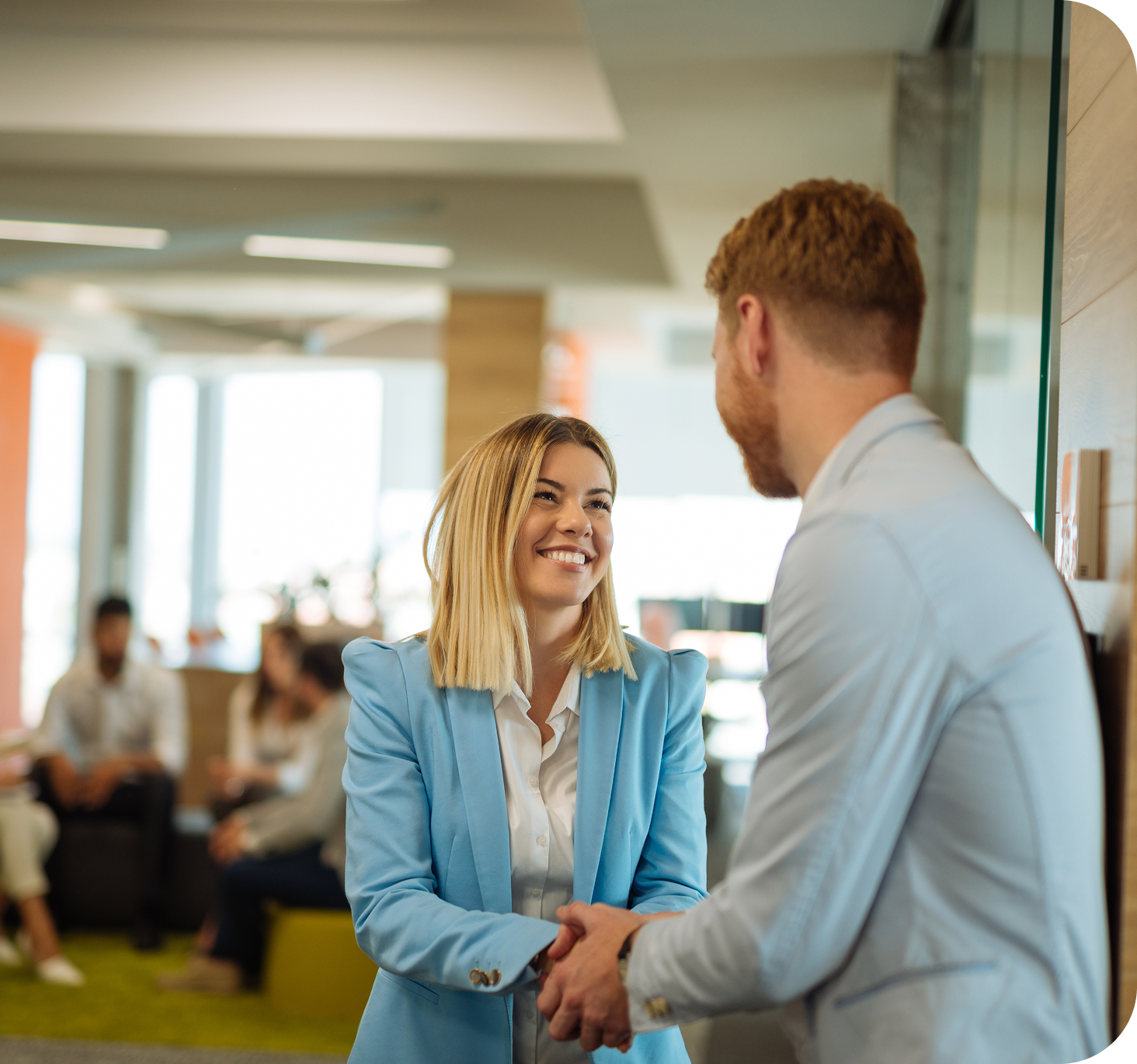 Two colleagues shaking hands in a modern office, representing company values